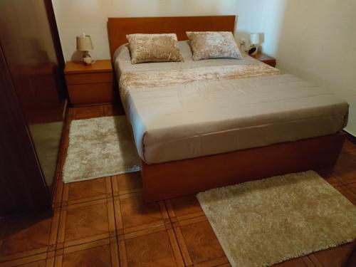 a bedroom with a bed with two rugs on it at Rochinha House in Funchal