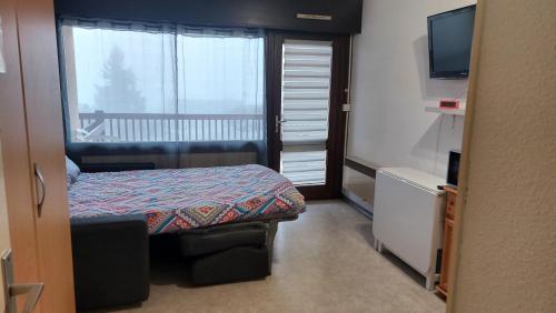 une petite chambre avec un lit et une fenêtre dans l'établissement Font-Romeu : Studio cabine avec terrasse., à Font-Romeu-Odeillo-Via