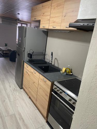 a kitchen with a refrigerator and a stove top oven at Chez Tikaf in Saint-Claude