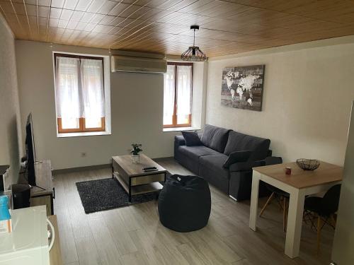 a living room with a couch and a table at Chez Tikaf in Saint-Claude