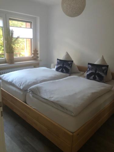 1 dormitorio con 1 cama grande con almohadas azules en Ferienwohnung Waschbärglück, en Hahnenklee-Bockswiese