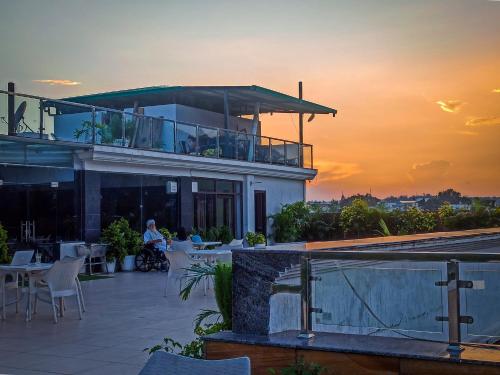 a building with a balcony with a sunset in the background at Indira Nikunj Rubystone Exotic in Rishīkesh