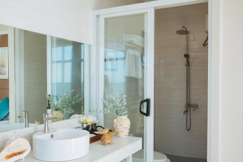 a bathroom with a sink and a shower at Seaward 270 degrees deluxe ocean view room with queen bed in Koror