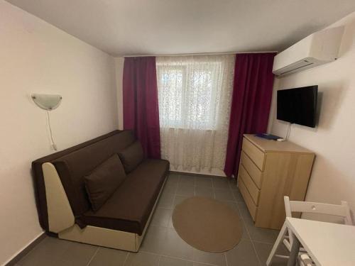 a small living room with a couch and a television at Delfin Apartments in Crikvenica