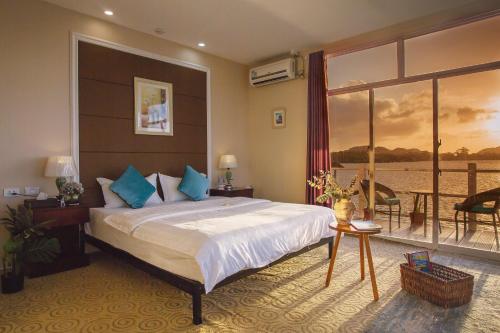 a bedroom with a large bed and a balcony at Seaward 270 degrees deluxe ocean view room with queen bed in Koror