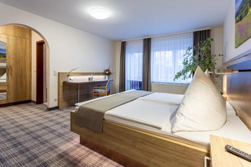 a hotel room with a bed and a desk at Hotel Zur Aussicht in Hohnstein