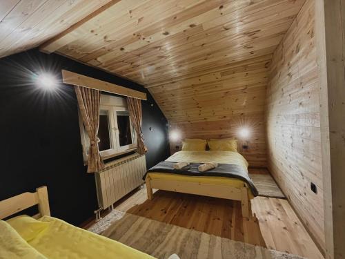 1 dormitorio con 1 cama en una habitación de madera en Apartman Kruna en Kolašin