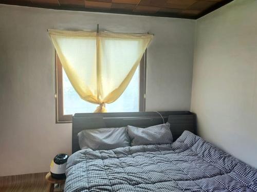 a bedroom with a bed in front of a window at Grandmother's Vegetable garden in Anseong