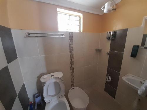 a bathroom with a toilet and a shower at Sparkle Residency in Nairobi
