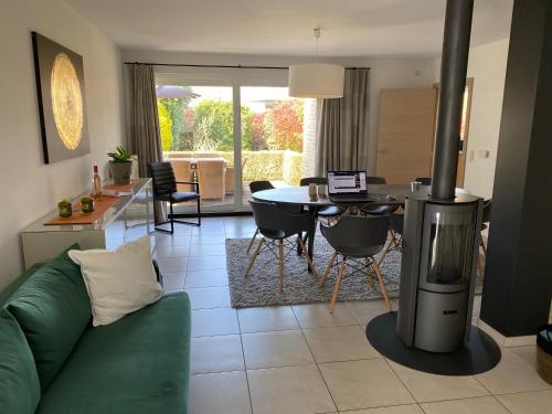 a living room with a green couch and a stove at Modern Spanish Hacienda - 10km from the coast in Ichtegem