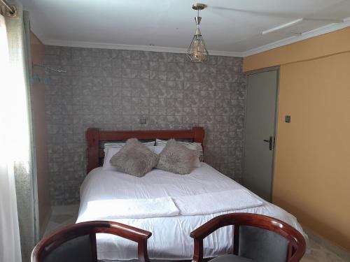 1 dormitorio con 2 almohadas en Sparkle Residency en Nairobi