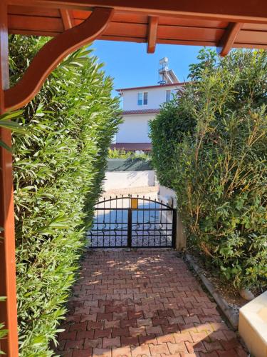 a gate into a garden with green bushes at Excellent 3 storey villa with a swimming pool in Belek
