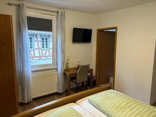 een slaapkamer met een bed, een bureau en een raam bij Bed and Breakfast - Rheingauer Hof in Oestrich-Winkel