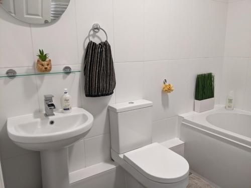 a white bathroom with a toilet and a sink at 3BD Coastal Retreat with Spectacular Sea Views in Folkestone