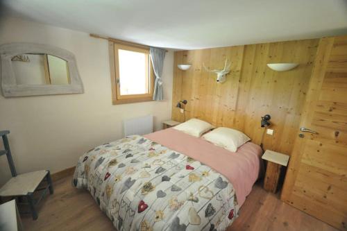 a bedroom with a bed in a room with wooden walls at Sweety home- Vue Mt-Blanc - A 15 min de pistes de ski in Sallanches