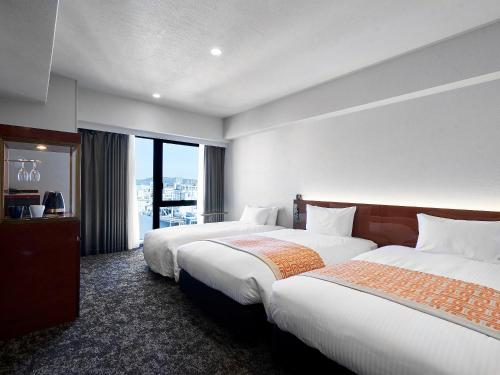 um quarto de hotel com duas camas e uma janela em Daiwa Roynet Hotel Kumamoto Ginzadori PREMIER - former Daiwa Roynet Hotel Kumamoto Ginzadori em Kumamoto