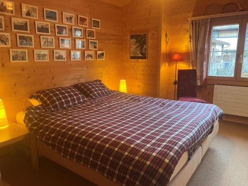 a bedroom with a bed and pictures on the wall at Gäuggeliweg 36, Klosters in Klosters