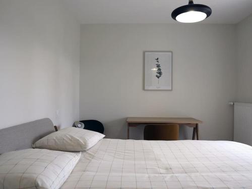 um quarto com uma cama branca e uma mesa em Maison 15 personnes périphérie de Clermont-Ferrand em Romagnat