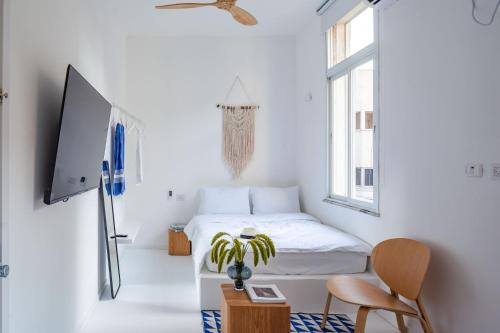 a bedroom with a bed and a tv and a chair at Isla apartment's in Tel Aviv