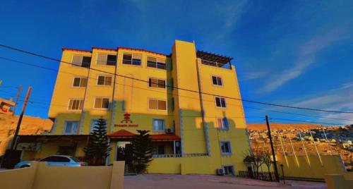 un edificio amarillo frente a un edificio en Shaqilath Hotel en Wadi Musa