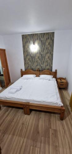 a bedroom with a large bed with white sheets at Vila Esperia Rânca in Ranca