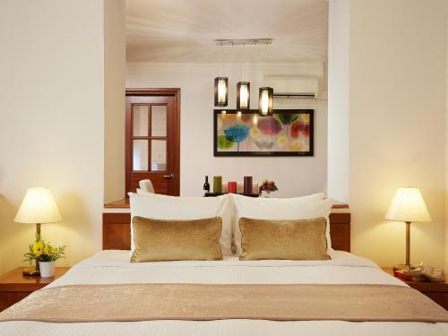 新加坡的住宿－遠東集團悅樂羅伯森碼頭公寓，一间卧室配有一张带两盏灯的大型白色床。