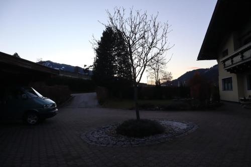 a car parked in a parking lot with a tree at Landhaus-Appartements Warraich in Schladming