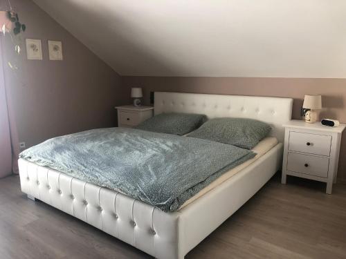 un letto bianco in una camera da letto con due comodini di Chalupa U Kubů a Plavy