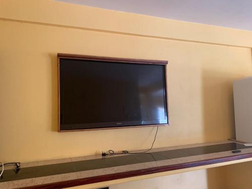 TV de pantalla plana colgada en la pared en Cummin up en Fort Jeudy