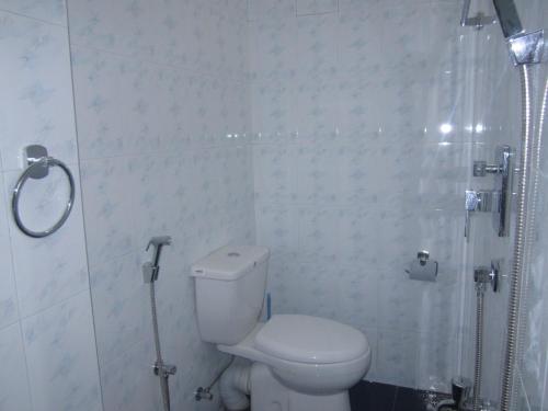 a white bathroom with a toilet and a shower at White Surfing Beach Resort in Unawatuna