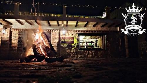 a fire in front of a brick building at night at La Villa de San Sebastian Hotel in Villa de Leyva