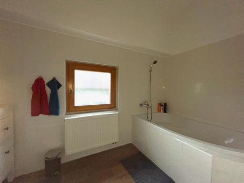 a bathroom with a large white tub and a window at Bílka 33 - Village home in the Czech Central Highlands in Bořislav
