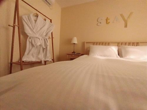 a bedroom with a bed and a dress hanging on the wall at אתיטיוד בערבה attitude at the arava in H̱aẕeva