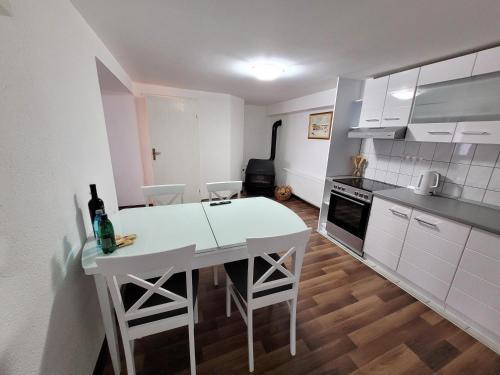 a kitchen with a white table and chairs in it at Apartman Studenac in Kiseljak