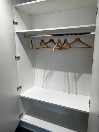 a white closet with wooden hangers in it at DayNight Sauveniere in Liège