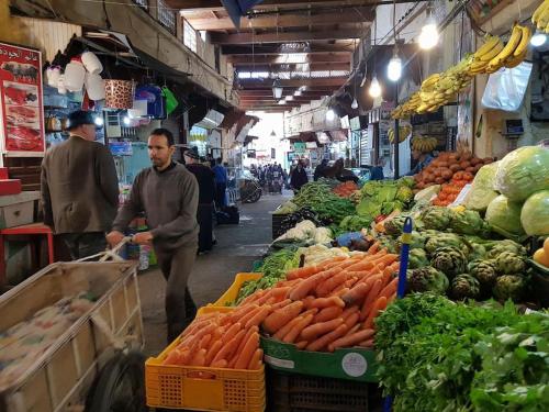 Un homme sur un marché avec des carottes et autres légumes dans l'établissement House in the old Medina of Fez, à Fès al Bali