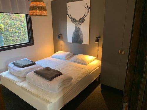 a bedroom with a bed with a deer painting on the wall at 5 beds Cabin in Tänndalen, Funäsdalen in Tänndalen