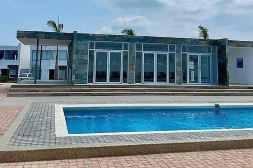 曼塔的住宿－Moderna casa con piscina y cerca de la playa，大楼前带游泳池的房子