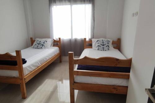 1 dormitorio con 2 literas y ventana en Moderna casa con piscina y cerca de la playa, en Manta