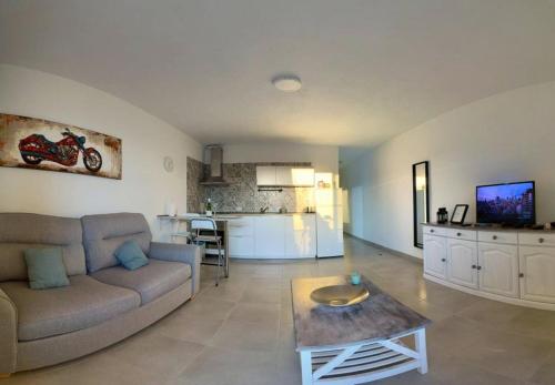 sala de estar con sofá, mesa y cocina en Sunny Halley apartament en El Médano