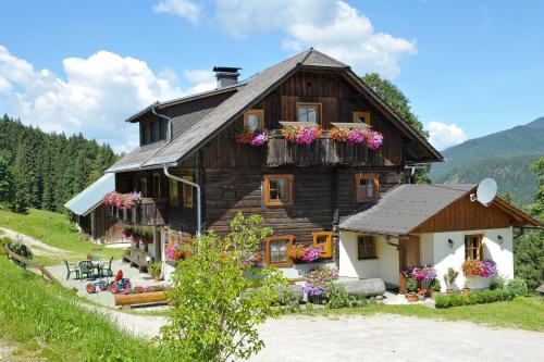 a large wooden house with flowers on the windows at Selbstversorgerhaus Herisch in Schladming