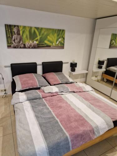 um quarto com uma cama com um cobertor listrado em Ni Va Li em Bretzenheim