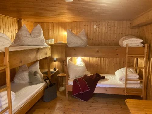 a room with three bunk beds in a cabin at Selbstversorgerhaus Herisch in Schladming