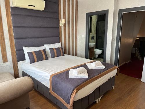 1 dormitorio con 1 cama con 2 toallas en Nova Roma Hotel, en Estambul