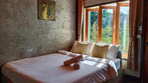 a bed sitting in a room with a window at PaiFamilyRESORT in Pai