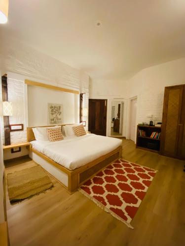 a bedroom with a large bed and a rug at The Lodge at Wah, Kandbari in Pālampur