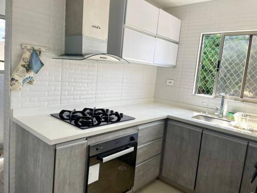 a kitchen with a stove and a sink in it at Apartamento en el epicentro del Carnaval in Barranquilla
