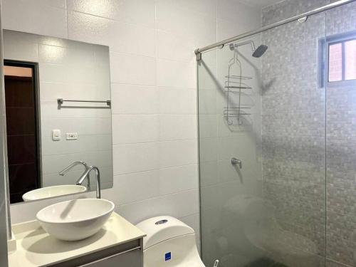 La salle de bains est pourvue de toilettes, d'un lavabo et d'une douche. dans l'établissement Apartamento en el epicentro del Carnaval, à Barranquilla