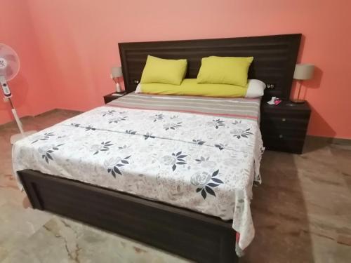 - un lit avec un couvre-lit noir et blanc et des oreillers jaunes dans l'établissement Solaimania Resort منتجع السليمانية, à Giza