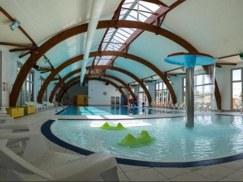a large swimming pool in a large building with a large ceiling at MOBIL HOME Tendance Tout Confort - FUNPASS non included in Gastes